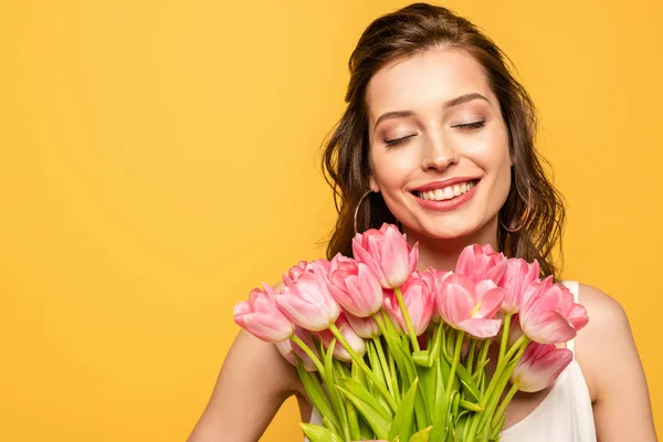 Молода Жінка Посміхаючись Закритими Очима Тримає Букет Рожевих Тюльпанів Ізольовано — стокове фото