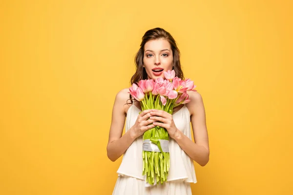 Zdumiona Młoda Kobieta Trzyma Bukiet Różowych Tulipanów Patrząc Aparat Odizolowany — Zdjęcie stockowe