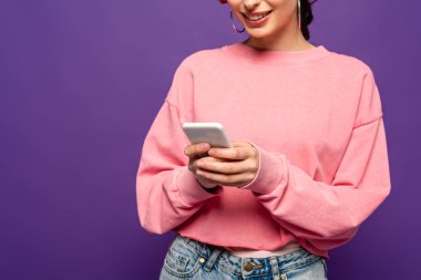 Mor renkte izole edilmiş akıllı telefondan gülümseyen kız sohbeti görüntüsü