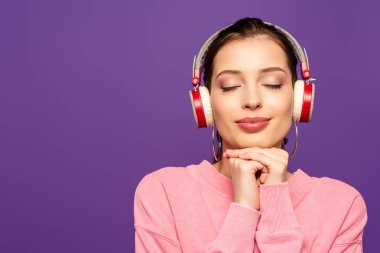 Gülümseyen, rüya gibi bir kız. Kablosuz kulaklıkla müzik dinliyor. Gözleri kapalı, mor renkte.