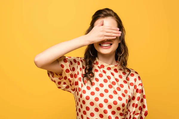 Jovem Mulher Sorrindo Enquanto Cobre Olhos Com Mão Isolada Amarelo — Fotografia de Stock