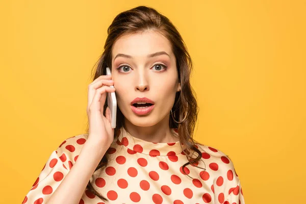 Shocked Young Woman Looking Camera While Talking Smartphone Isolated Yellow — Stock Photo, Image