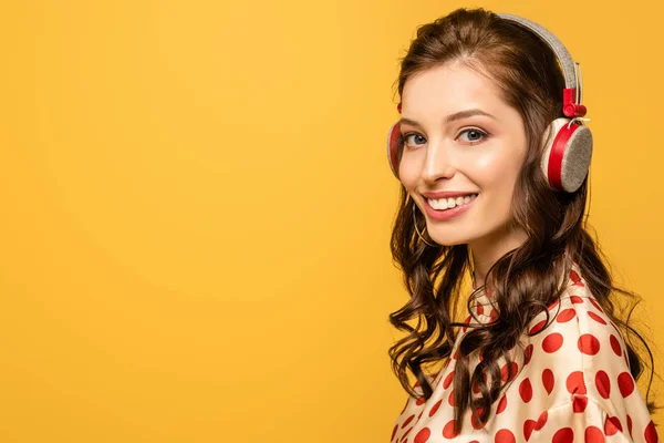 Szczęśliwa Młoda Kobieta Słuchawkach Bezprzewodowych Uśmiechnięta Kamery Odizolowana Żółto — Zdjęcie stockowe