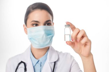Selective focus of doctor in medical mask holding jar with vaccine isolated on white clipart