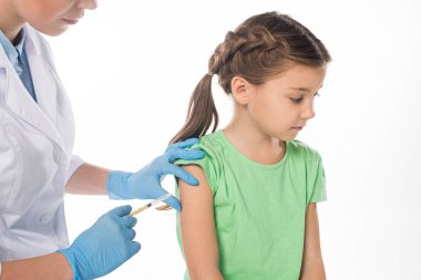 Pediyatrist beyazlar içinde izole edilmiş bir çocuğa aşı enjekte ediyor.