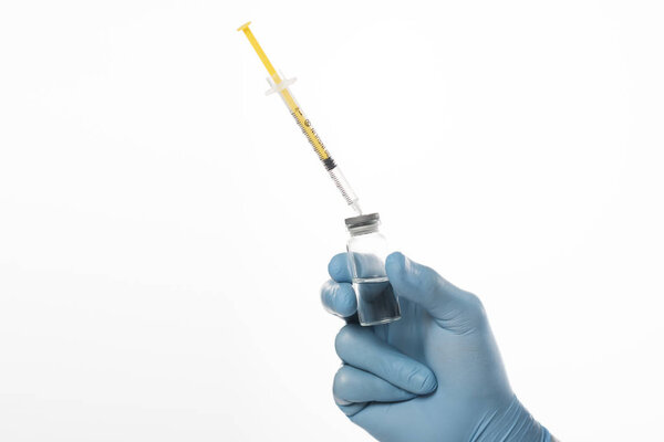 Cropped view of doctor in latex glove holding jar of vaccine and syringe isolated on white