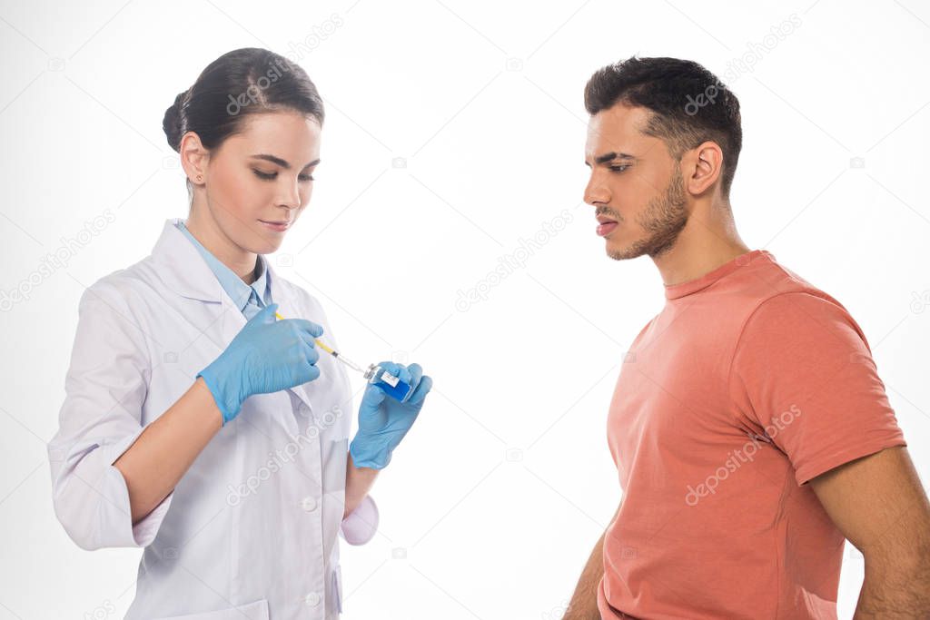 Side view of doctor picking up flu vaccine near patient isolated on white