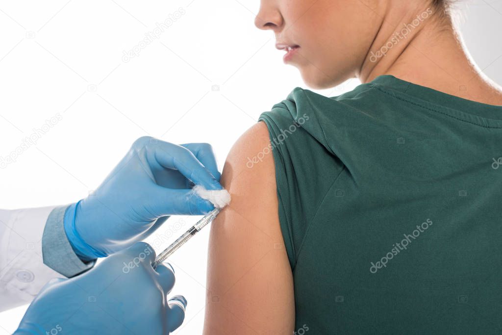 Cropped view of doctor with cotton wool and syringe doing vaccine injection to patient isolated on white