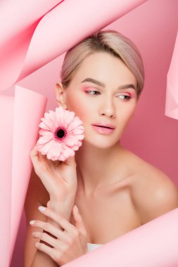 Pembe çiçekli güzel kız ve yırtık kağıtta pembe makyajlı.