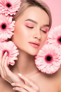 Pembe makyajlı ve pembe çiçekli çekici bir kız.
