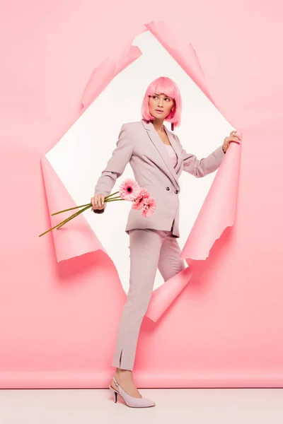 Stijlvolle Vrouw Pak Roze Pruik Met Bloemen Poseren Gescheurd Papier — Stockfoto