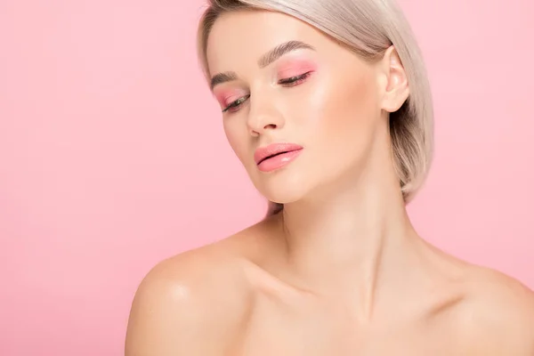 naked blonde girl with pink makeup, isolated on pink