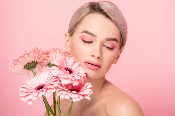 ピンクのガーベラの花を持つ美しいヌードの女の子は ピンクに隔離され — ストック写真