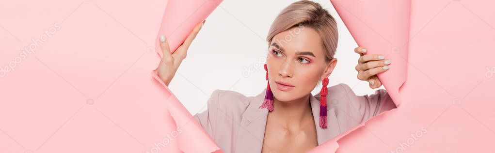 panoramic shot of beautiful girl in trendy suit posing in torn paper, isolated on white