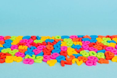 Mavi yüzeyde kopyalama alanı olan renkli plastik sayılar