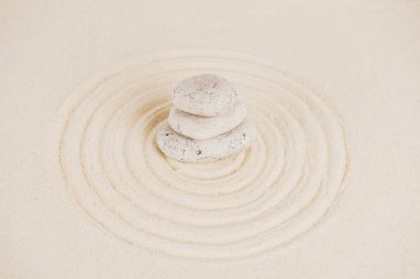 Stack of zen stones on sand surface with circles clipart
