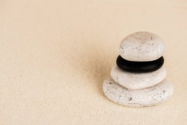 Close up view of zen stones on sand surface clipart