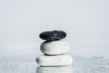 Wet zen stones on glass with water drops isolated on grey  clipart