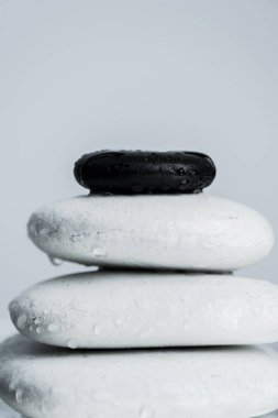 Macro shot of black and white zen stones in water drops isolated on grey clipart