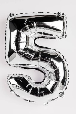 Gri arkaplanda beş numara şeklinde gümüş balon