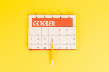 Top view of pencil on calendar with november month on yellow background clipart