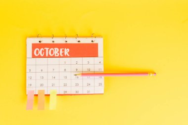 Top view of pencil on calendar with november month and sticky notes on dates on yellow background clipart