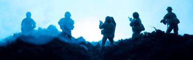 Mavi arka planda dumanı olan oyuncak askerlerin savaş sahnesi, panoramik çekim