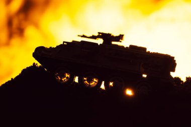 Oyuncak tankla savaş sahnesi ve arka planda yangın