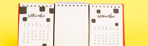 Панорамный кадр календаря с осенними месяцами и пустым пустым цветом на желтом фоне
