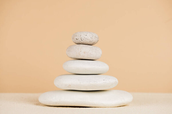 Крупный план укладываемых камней дзен на песке, изолированных на бежевом
 