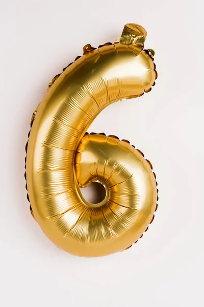 Golden balloon in shape of six number on grey background
