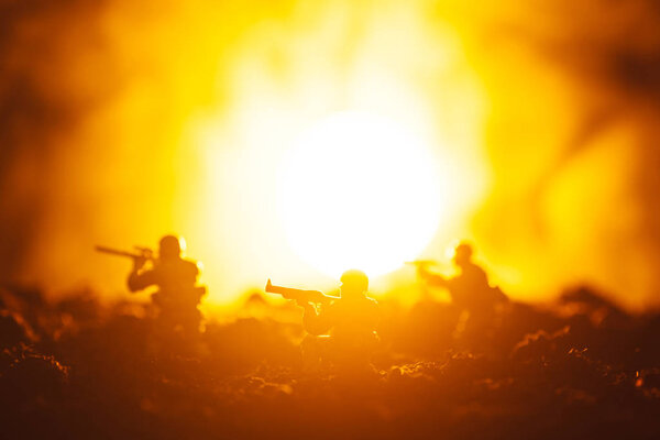 Battle scene with toy warriors in smoke and sunset at background
