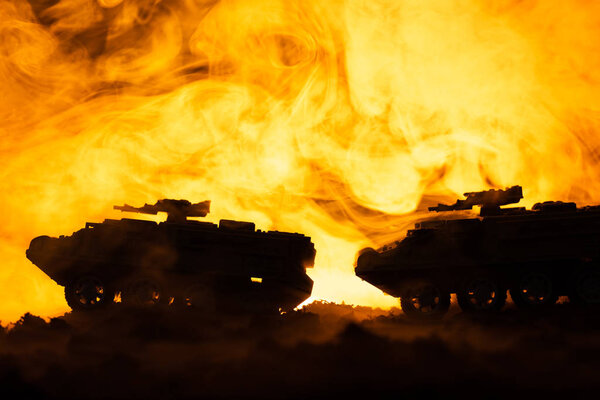 Battle scene with toy tanks and fire at background