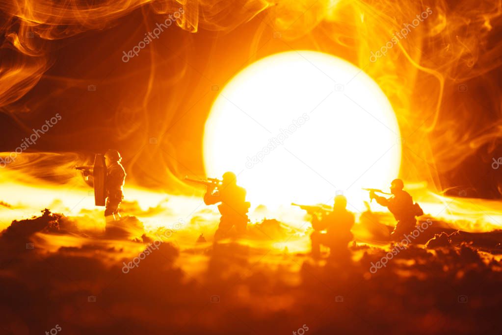 Battle scene of toy soldiers in smoke with sunset at background