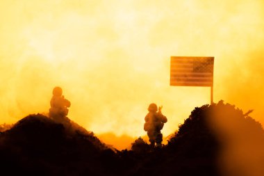 Amerikan bayrağının yanında oyuncak askerlerle savaş sahnesi
