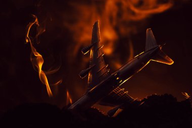 Siyah arka planda dumanı olan oyuncak uçak kazası, savaş sahnesi