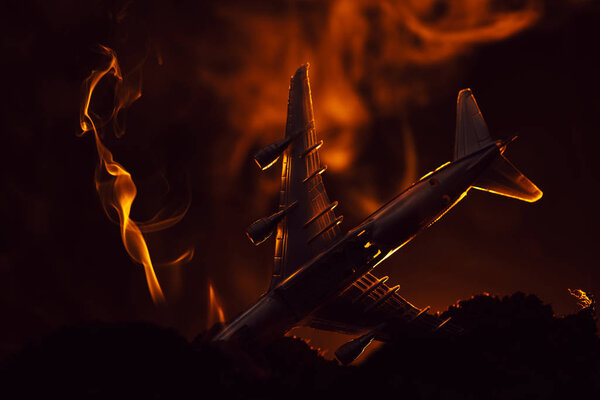 Crash of toy plane with smoke on black background, battle scene