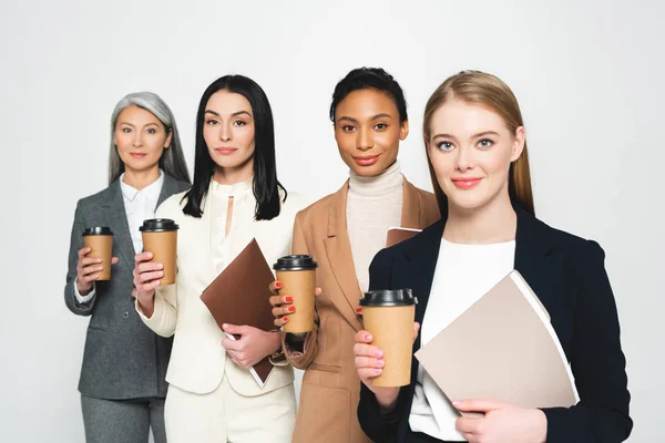 Four Cheerful Multicultural Businesswomen Holding Folders Paper Cups Isolated White — Stock Photo, Image