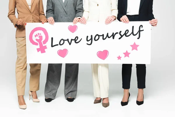 多文化女商人拿着写着 爱你自己 的标语牌 用白字写着 爱你自己 的观点 — 图库照片