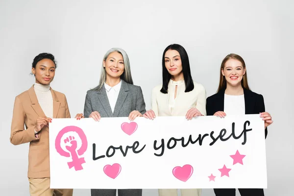 Gelukkig Multiculturele Zakenvrouwen Houden Poster Met Liefde Jezelf Belettering Geïsoleerd — Stockfoto