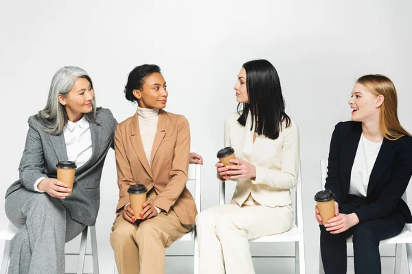 Mutlu Çok Kültürlü Takım Elbiseli Kadınları Sandalyeye Oturur Beyaz Bardaklara — Stok fotoğraf