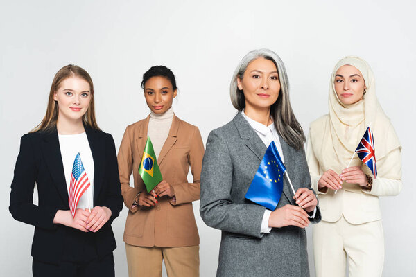 multicultural businesswomen with flags of different countries isolated on white 