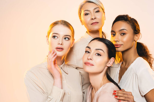 beautiful multicultural women with makeup isolated on beige 