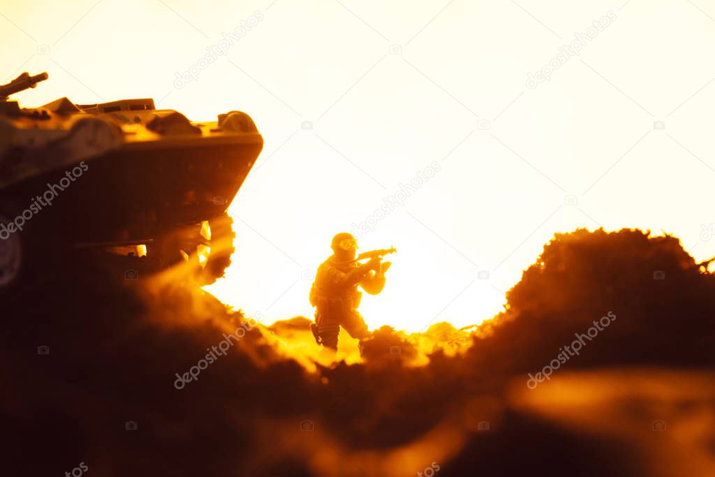 Battle scene with toy soldier near tank on battleground on yellow background