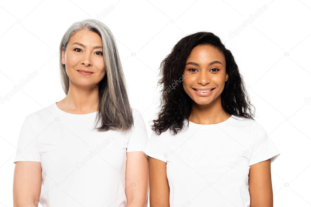 happy african american and asian women looking at camera isolated on white 