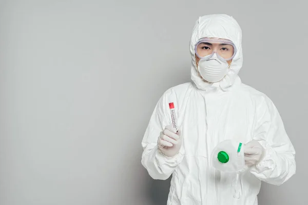 Asiatischer Epidemiologe Warnanzug Blickt Die Kamera Während Atemschutzmaske Und Reagenzglas — Stockfoto