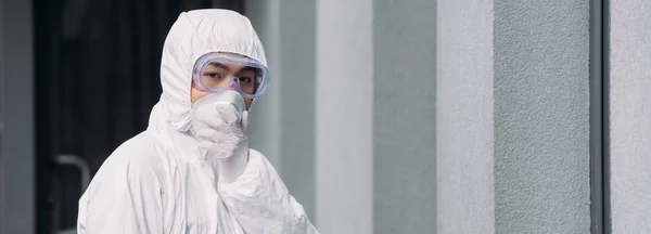 Panoramica Asiatico Epidemiologo Hazmat Tuta Respiratore Maschera Guardando Fotocamera Mentre — Foto Stock