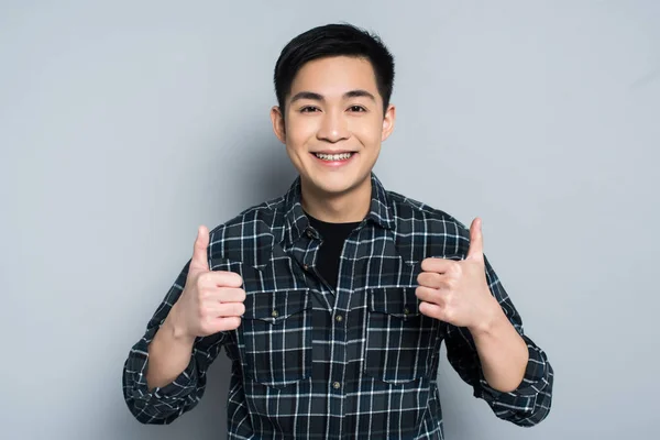 Smiling Asian Man Looking Camera While Showing Thumbs Grey Background — Stockfoto