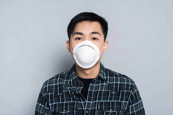 Jong Aziatische Man Respirator Masker Kijken Naar Camera Grijze Achtergrond — Stockfoto