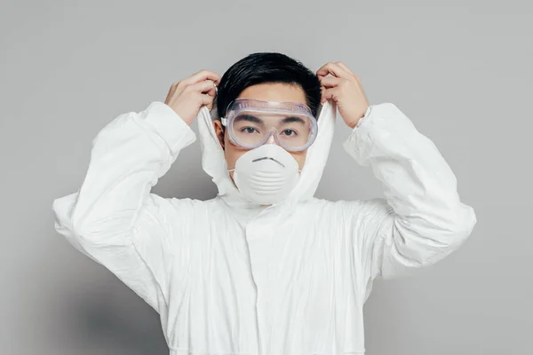 Asian Epidemiologist Hazmat Suit Respirator Mask Putting Hood While Looking Stock Photo